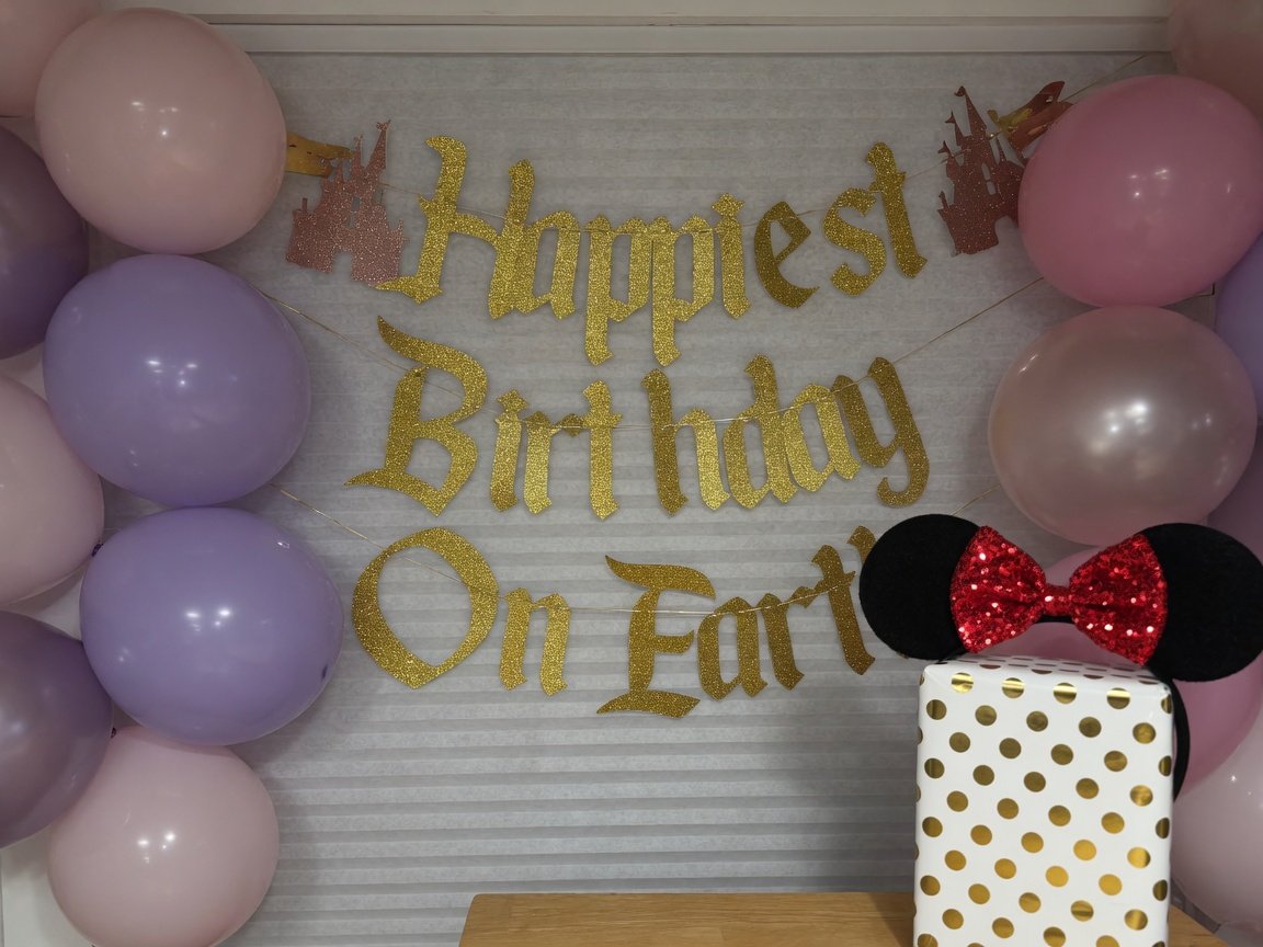 Happiest Birthday on Earth balloon and banner surprise wall with Minnie ears gift