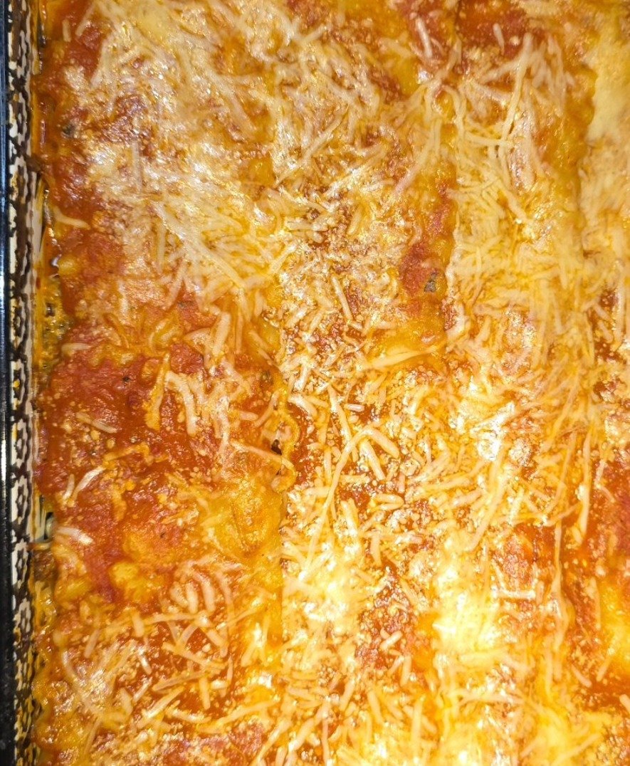 Homemade lasagna in a glass baking dish with golden melted cheese